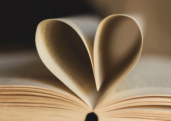 Aufgeschlagenes Buch mit als Herz geformten zwei Seiten